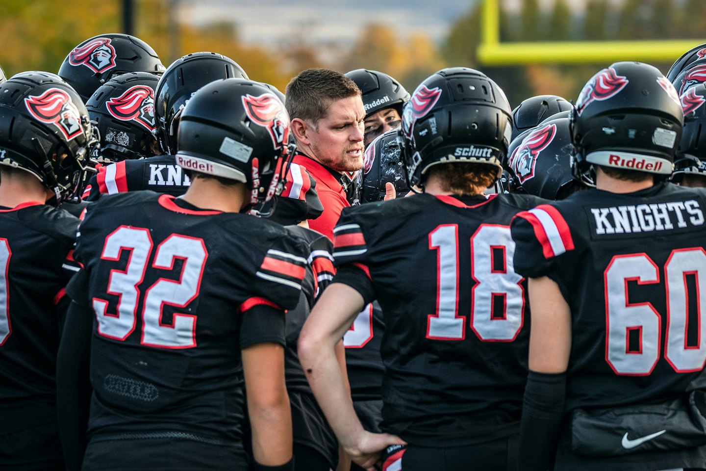 Football coach speaking to his players on the field.